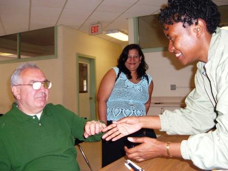 Ron Farris chats with Elaine Laird as Iris Gomes watches