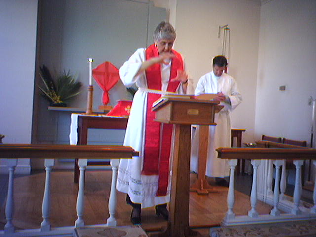 Mother Barbara reading the Gospel while LEM Tom Hattaway bows his head