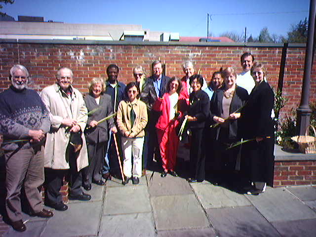 St.Barnabas members standing in columbarium garden with palm leaves, ready to process into St. Mary's Chapel