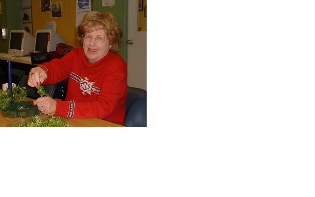 Christina Duley pauses from creating an Advent Wreath to smile for camera