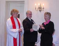 Beth Hill and Steve Holst present a book of common prayer to our new vicar